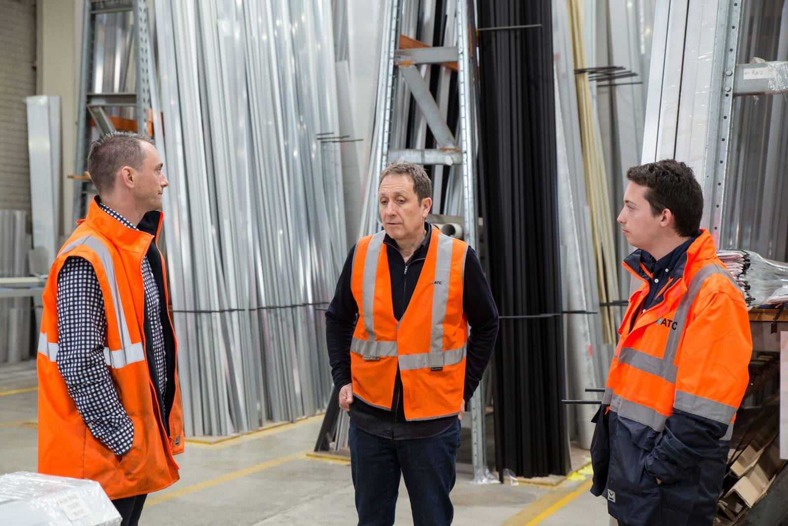 Equipe com colete refletivo em galpão industrial