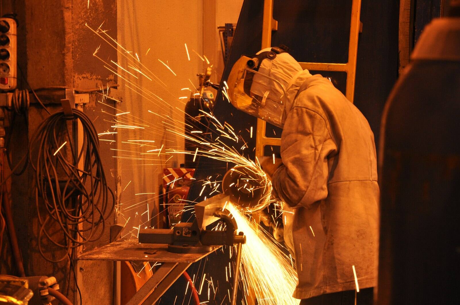 Soldador com máscara e avental de proteção