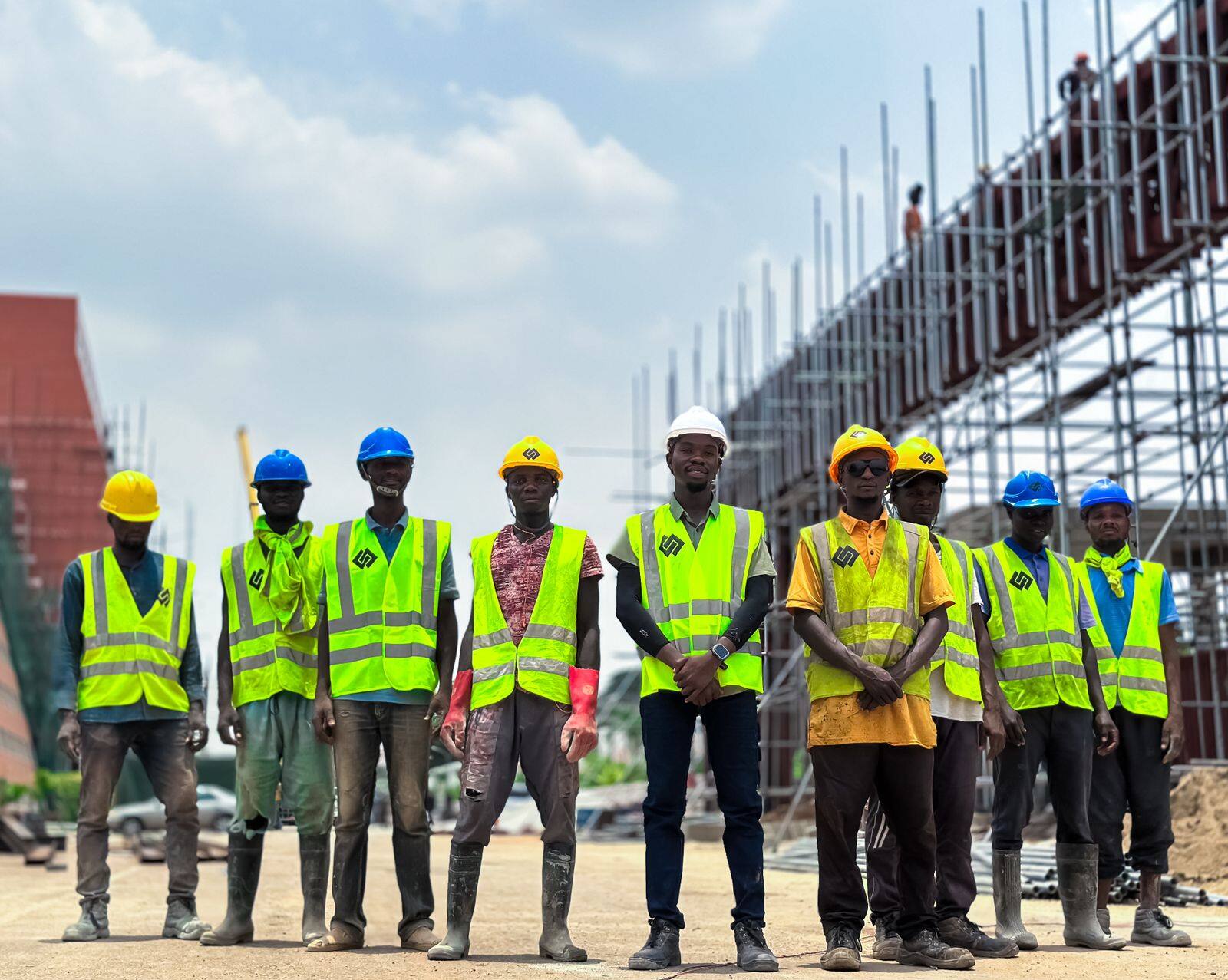 Equipe com colete refletivo e capacete em canteiro de obras